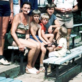 Family group posing outdoors at stadium seating area.