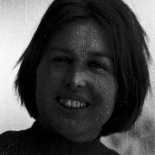 Smiling person with short hair in vintage photo.