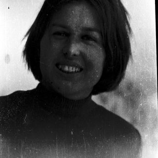 Smiling person with short hair in vintage photo.