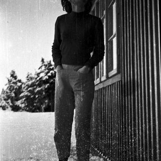 Person standing in light snow near building.