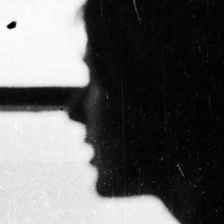 Silhouette of person looking out window.
