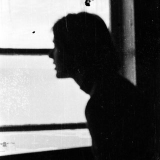Silhouette of person looking out window.