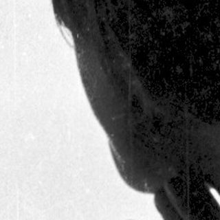 Silhouette of person leaning on window.