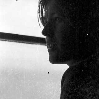 Person standing under shower with water droplets.