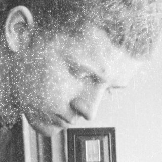 Person using vintage twin-lens reflex camera indoors.