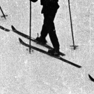 Skiers ascending snow-covered mountain slope.