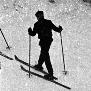 Skiers ascending snow-covered mountain slope.