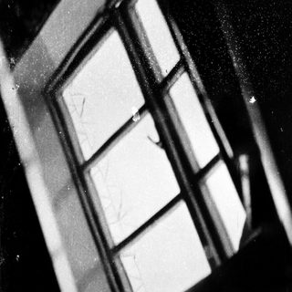 Old, scratched, partially fogged-up window pane.
