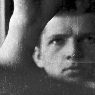 A person resting their head on a window sill.