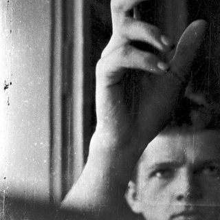 A person resting their head on a window sill.