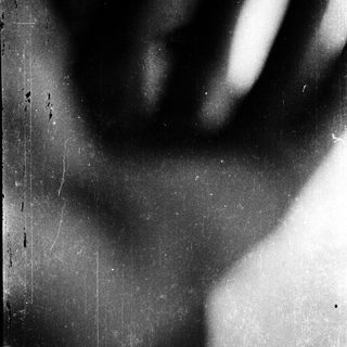 Silhouette of hand on textured surface.