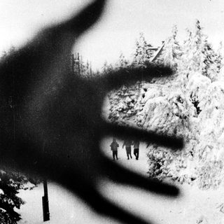 Shadows of people climbing snowy mountain slope.