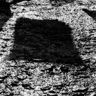 Pothole in cracked asphalt road surface.