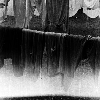 Clothes drying in rain near waterfall.