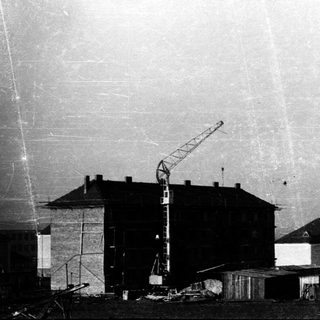 Construction site with crane and partially built multi-story building.