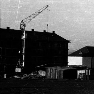 Industrial construction site with crane and buildings.