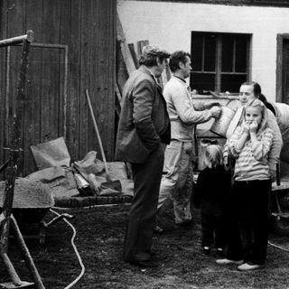 People gathered around a woman in a courtyard.