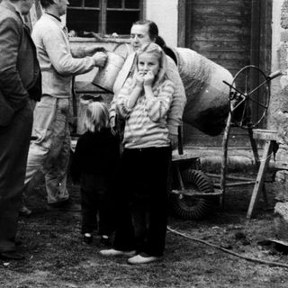 People gathered around a woman in a courtyard.