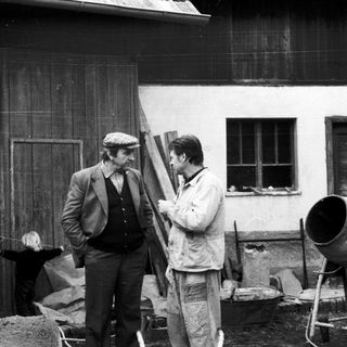 Two men inspecting construction materials at a building site.