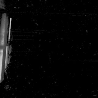Dark room with single open window revealing light outside.