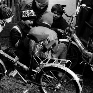 Five children with bicycles in a backyard.