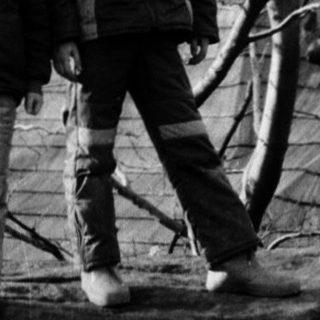 Two people standing outdoors in winter attire.