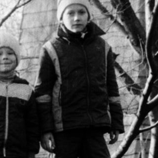 Two people standing outdoors in winter attire.