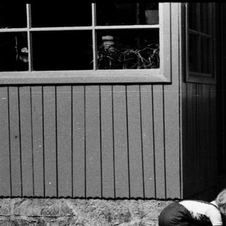 Two children playing with a toy car outdoors.