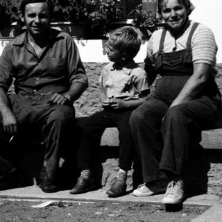 Family posing together outdoors near a building.