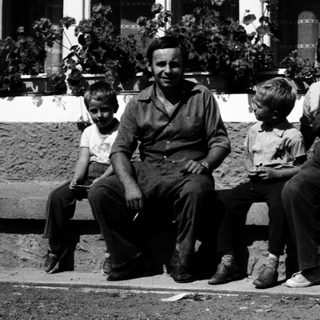 Family posing together outdoors near a building.