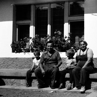 Family posing together outdoors near a building.
