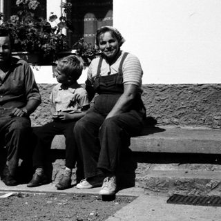 Family posing together outdoors near a building.
