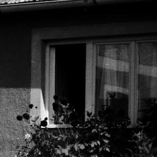 Family relaxing outdoors near house.