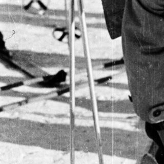 Ski racer bending forward in competitive downhill skiing.