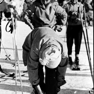 Ski racer bending forward in competitive downhill skiing.