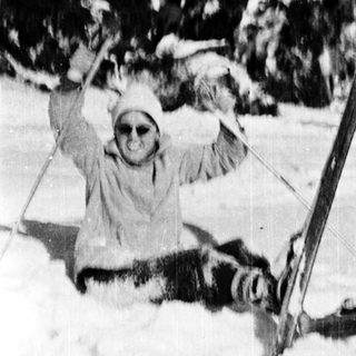 Person skiing and falling in snow-covered terrain.