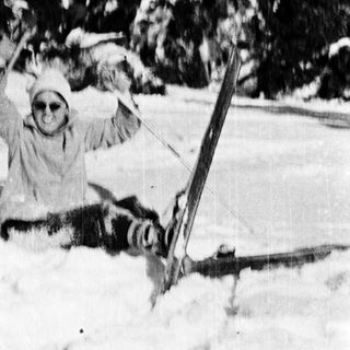 Person skiing and falling in snow-covered terrain.