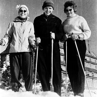 Three women posing with cross-country skiing equipment.