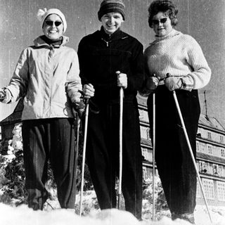 Three women posing with cross-country skiing equipment.
