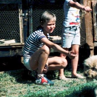 Children interacting with farm animals outdoors.