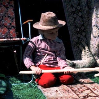 Two people playing traditional stick-and-bone games outdoors.