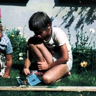 Two children playing outside with a board game.