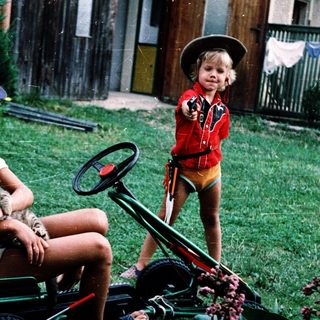 Two children playing with toy vehicles outdoors.