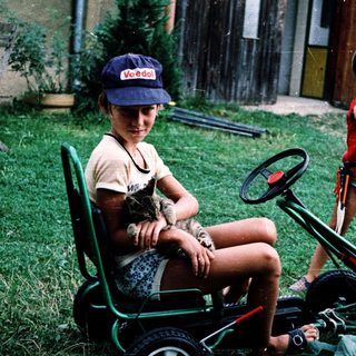 Two children playing with toy vehicles outdoors.