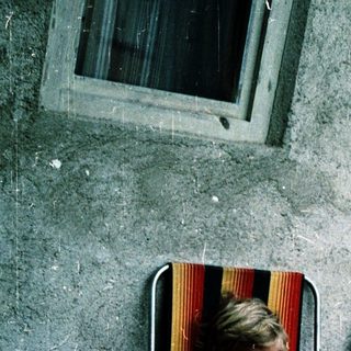 Child sitting alone on folding chair outdoors.