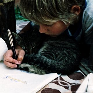 A child drawing with a pen indoors.