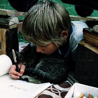 A child drawing with a pen indoors.
