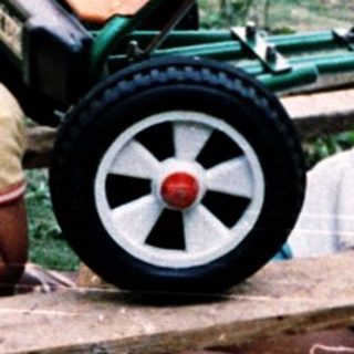 Two children playing with toy lawn mowers.