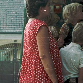 Family examining colorful toy display at outdoor market.