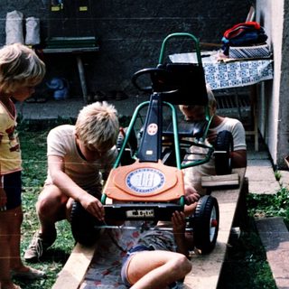 Children playing with homemade toy race car.